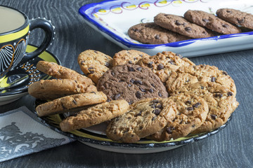 Encas avec cookies chocolat et caramel dans une assiette et plat sur fond sombre