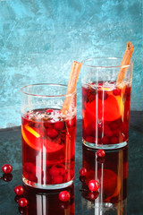 Spicy Christmas drink in a glass with spices, cranberries and lemon