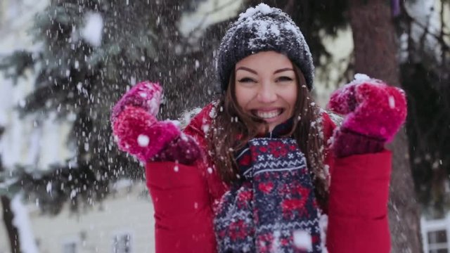 Portrait happy young beautiful woman standing park falls snow smiles christmas snowball winter young beautiful girl happiness joy outdoor throwing white hat holiday park play attractive slow motion