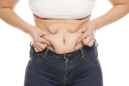 fat deposits in the belly of young women on white background