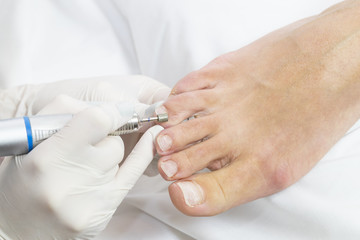 Female foot in the process of pedicure procedure in a beauty salon close-up.