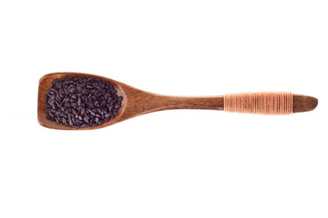 spice black sesame seeds in  wooden spoon isolated on a white background, top view