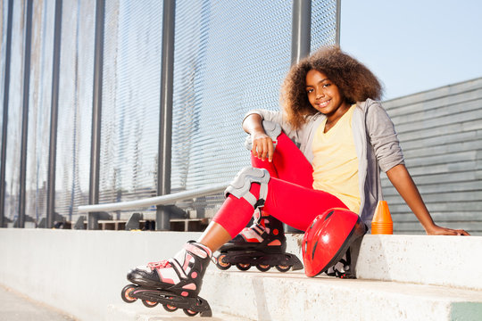 Girl sitting on the stairs in roller skates