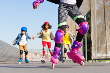 Fototapeta na wymiar Kids rollerblading in protective gear outdoors