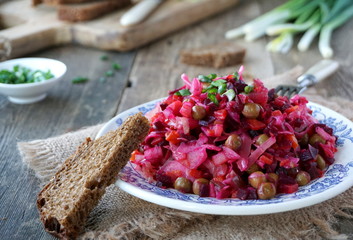 Russian beetroot salad with sauerkraut, carrots, potatoes, green peas, pickled cucumbers and onions