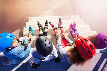 Young in-line skaters sitting on stairs outdoors