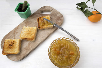 A sandwich with mandarin jam and tangerine jam is located on a light table.