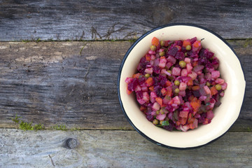 Salad of beetroot from beets, potatoes, pickles, onions, carrots, green peas, greens and seasonings.