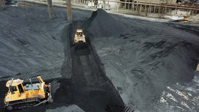 Tracor raking coal