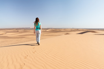 Femme marchant dans le désert du Sahara