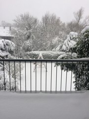Blick vom verschneiten Balkon in den Garten im Schnee