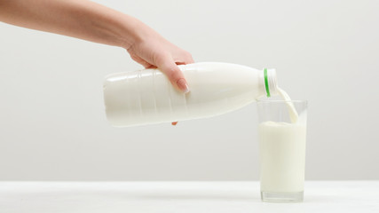 Woman pours milk. Dairy products. Calcium ,vitamin D and amino acids concept. Fitness lifestyle.