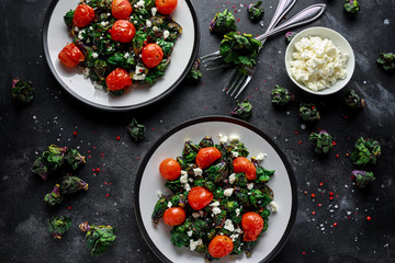 Homemade Roasted Green Kalettes salad with cherry tomatoes and feta cheese. healthy food