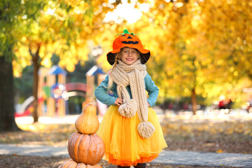 Cute little girl wearing Halloween costume in autumn park