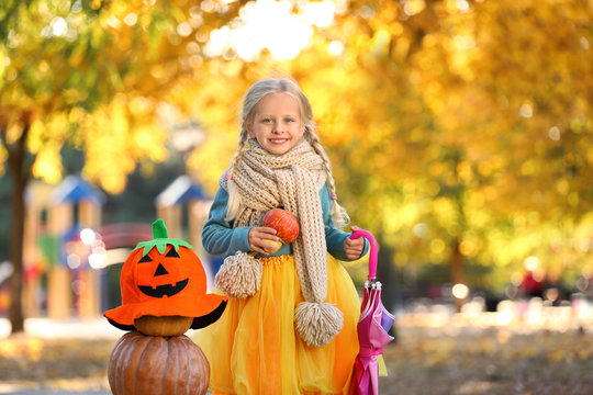 Cute little girl wearing Halloween costume in autumn park