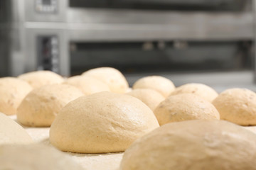 Fototapeta na wymiar Raw loaves of bread on table in bakery