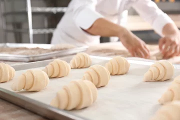 Foto op Plexiglas Bakkerij Raw crescent rolls on table in bakery