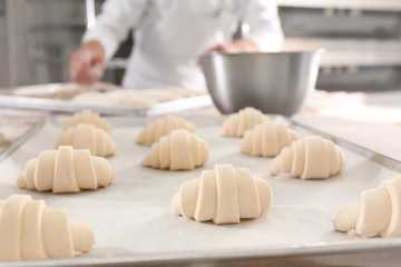 Raw crescent rolls on table in bakery