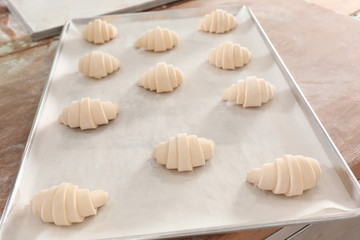 Raw crescent rolls on table in bakery