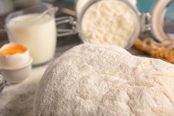 Fresh raw dough on table, closeup