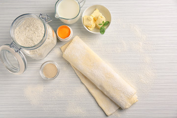 Composition with fresh raw puff dough on table