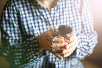 Women's hands hold a cup of tea, toning