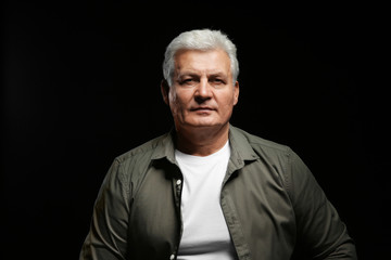 Handsome senior man in casual clothes on black background