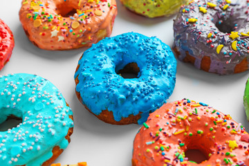 Tasty colorful donuts on white background