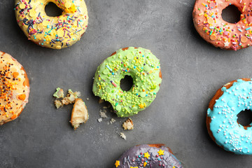 Colorful donuts with sprinkles on grey background