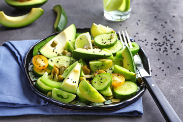 Plate with delicious vegetable salad on table