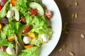 Plate with delicious vegetable salad on table, closeup