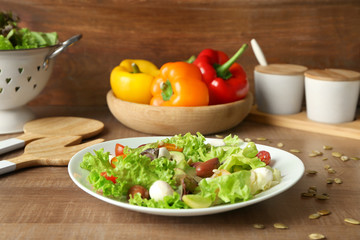 Plate with delicious vegetable salad on table