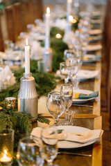 nature, eco friendly, dinner concept. close up of glasses that placed nearby with plate and candle holders, all the lights of the dining hall are reflected in them. that is why they are almost shining