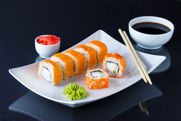 Various kinds of sushi served on black background.
