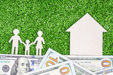 Abstract symbol house and family against green grass background on foundation of money 100 dollars. concept of solid foundation