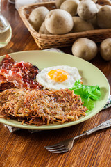 Hash browns. Potato pancakes with crispy fried bacon and fried egg