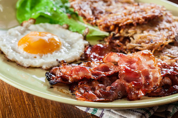 Hash browns. Potato pancakes with crispy fried bacon and fried egg