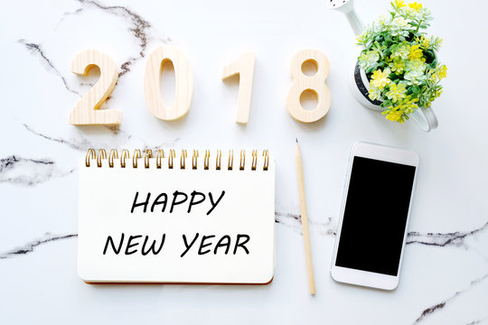 2018 happy new year and white smart phone with blank screen on white marble table background, 2018 new year greeting card, mock up, template, top view