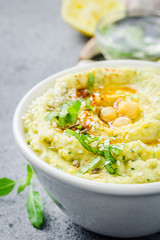Spicy creamy hummus in a bowl on stone or concrete background. Selective focus, copy space, close up. 