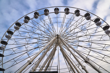 Construction and wagons of the  Ferris wheel  against the sky in Poznan.