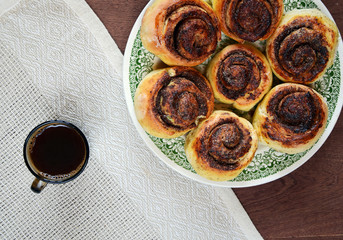 coffee cup and plate of snail rolls filled with carob