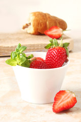 croissants with chocolate cream and berries strawberries on a light background