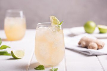 Fresh cocktail prepared with ginger beer, lime and ice. White table