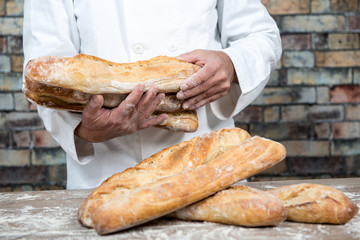 baker holding traditional bread french baguettes