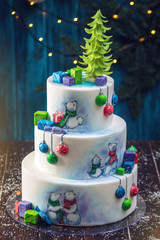 Christmas colorful three-Tiered cake decorated with drawings of Teddy bears, gift boxes and a green tree top