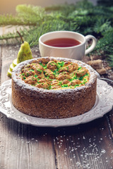 Homemade Christmas or New Year holiday pear pie decorated in a rustic style. Concept of festive desserts
