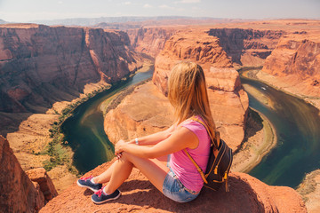 Young girl standing at the edge of the cliff at the Horse Shoe Bend, USA
