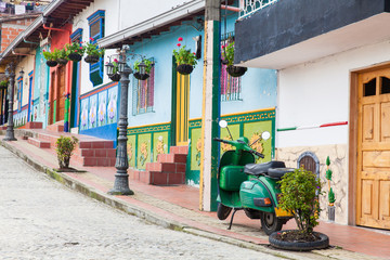 Naklejka premium Green motorcycle at the colorful town of Guatape, Antioquia – Colombia.