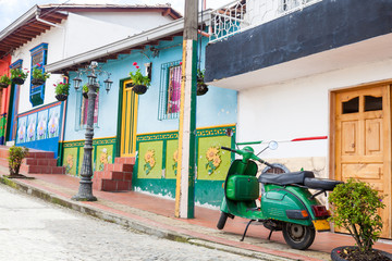 Fototapeta na wymiar Green motorcycle at the colorful town of Guatape, Antioquia – Colombia.