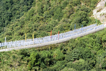 Fototapeta na wymiar Buddhist Prayer Flags on a road bridge near Trashigang - Eastern Bhutan